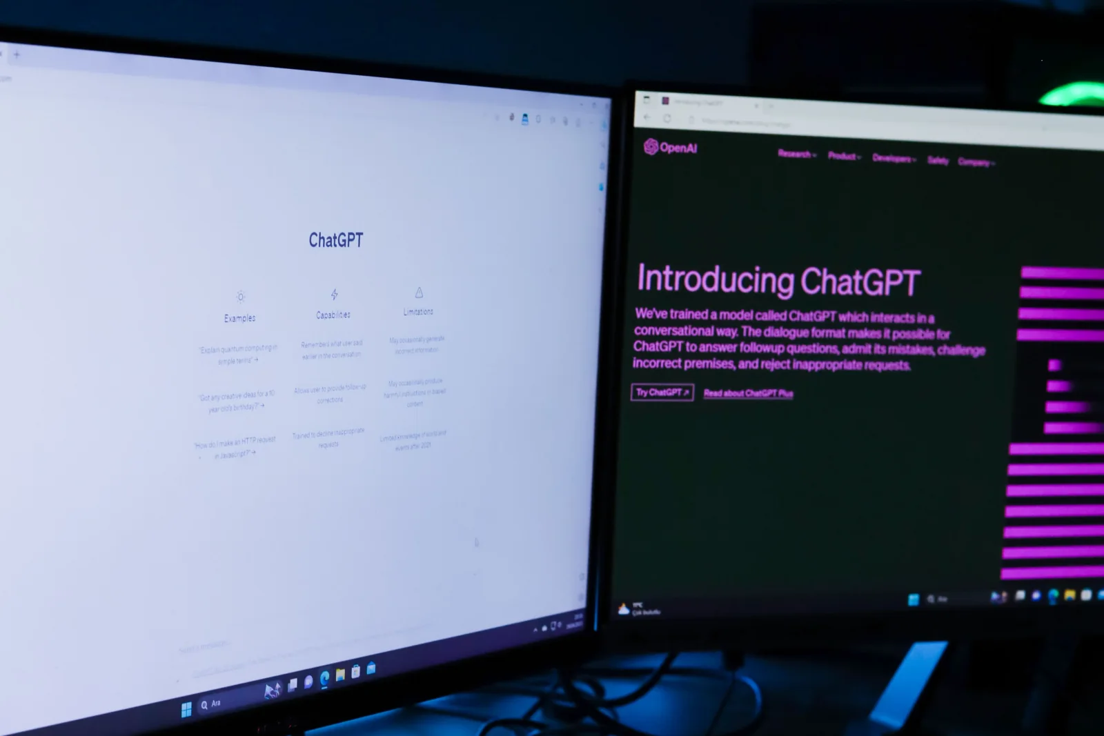 Dois monitores em uma estação de trabalho exibem páginas do ChatGPT e da OpenAI.